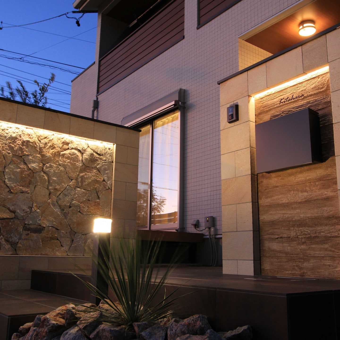 自然石のアプローチとモルタル造形の看板とテラス