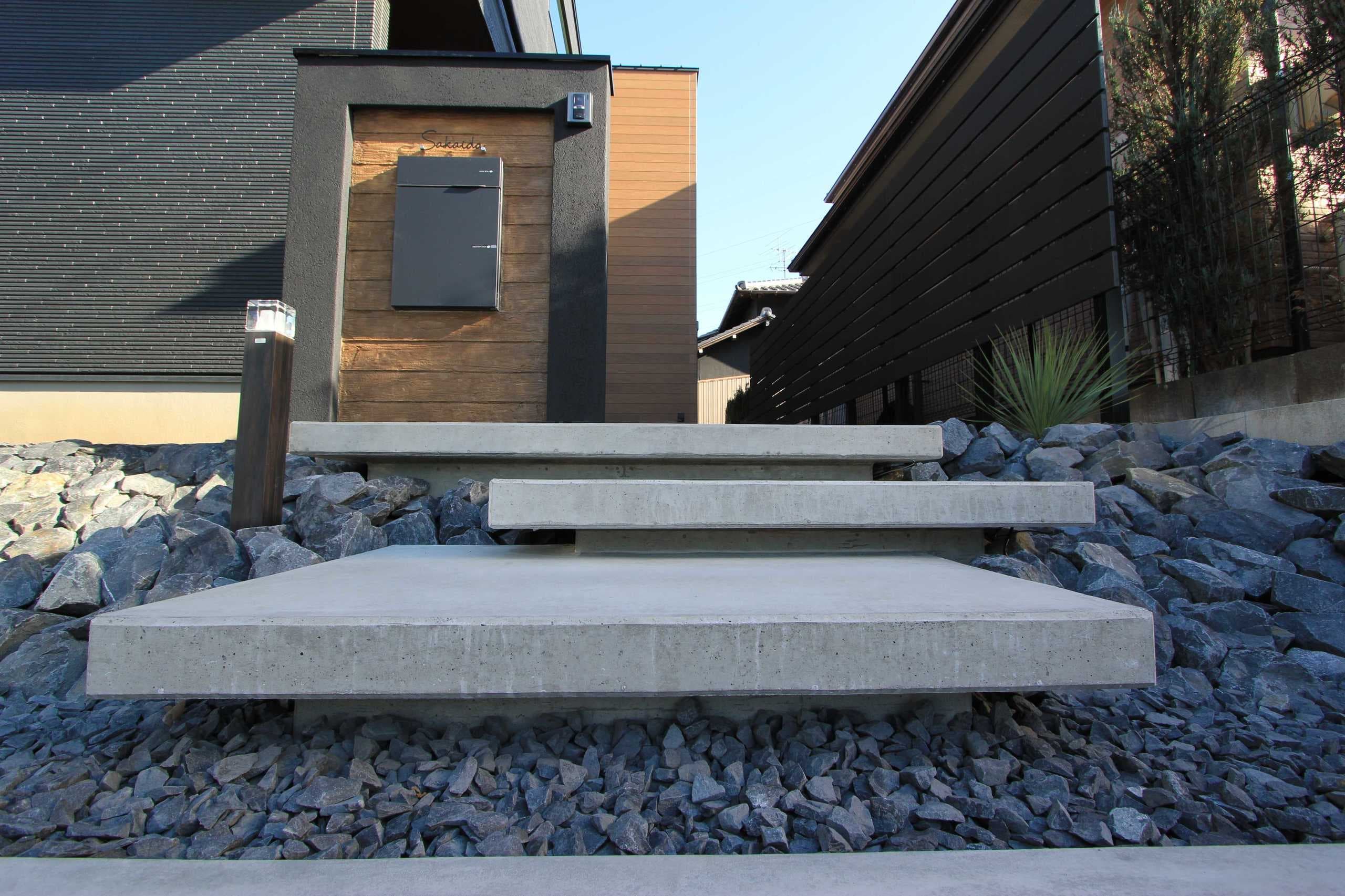 手造りのコンクリート浮き階段によるアプローチ