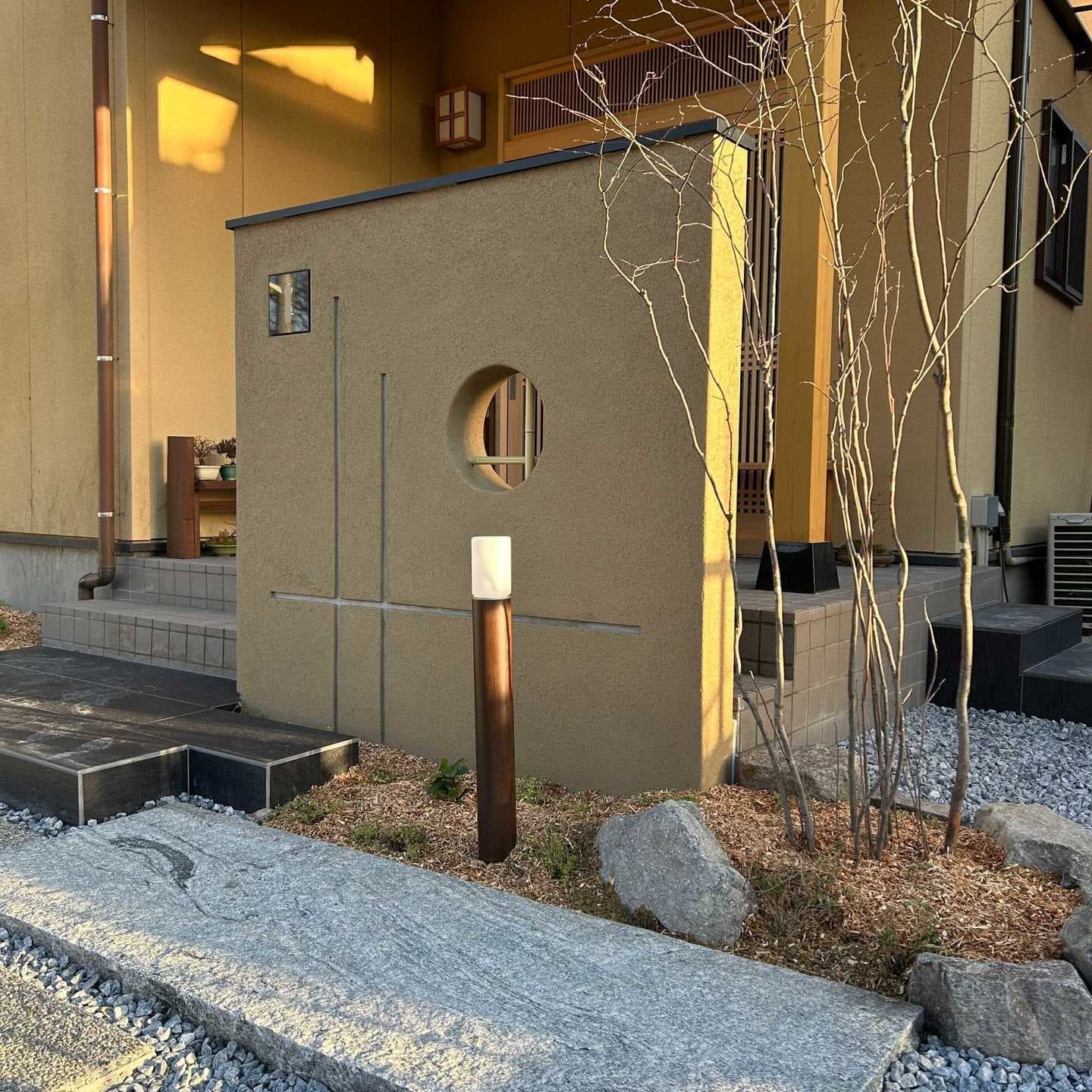 黒の外壁を背景に植えられたアオダモとヤマコウバシ